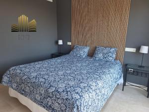 a bedroom with a bed with a blue comforter at Exclusive Penthouse Privacy and Sea View in Vistamar KniTorroxCosta in Torrox Costa