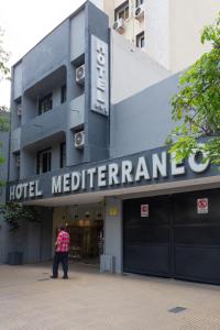 a man standing in front of a hotel mediterrand at Hotel Mediterraneo in San Miguel de Tucumán
