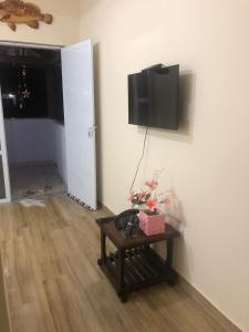 a room with a table and a tv on the wall at Recanto do Peró in Cabo Frio