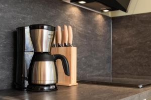 a coffee maker on a counter next to a block of knives at Bunter Hund Apartments - Hund, Parkplatz, Wintergarten in Rothenburg ob der Tauber