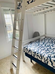 a bedroom with a bunk bed and a ladder at Chipiona Center in Chipiona +37 photos