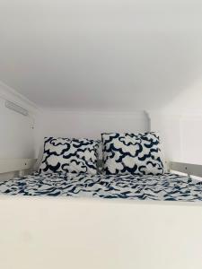 a white bed with blue and white sheets and pillows at Chipiona Center in Chipiona