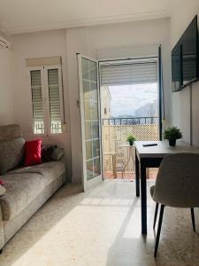 a living room with a couch and a table at Chipiona Center in Chipiona