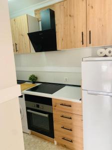 a kitchen with a stove top oven next to a refrigerator at Chipiona Center in Chipiona
