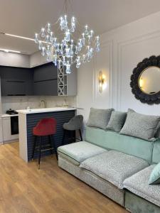 トビリシにあるNew apartment in Saburtaloのソファとシャンデリアのあるリビングルーム