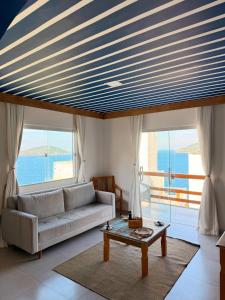 een woonkamer met een bank en een tafel bij Suíte Atenas com hidro aquecida - Arraial do Cabo in Arraial do Cabo