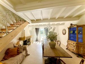 a living room with a couch and a table and stairs at La Batisse de Reve in Saint-Martin-dʼArdèche
