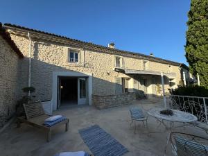 a patio with a table and chairs and a building at La Batisse de Reve in Saint-Martin-dʼArdèche