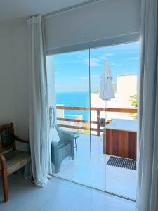 een kamer met uitzicht op een bad en een balkon bij Suíte Atenas com hidro aquecida - Arraial do Cabo in Arraial do Cabo +15 foto's