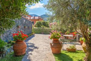 a garden with large pots of flowers and a table at PORTOVECCHIO Plus in Levanto
