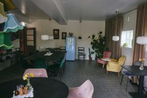 a room with tables and chairs and a blue refrigerator at Folk och Fä in Grisslehamn