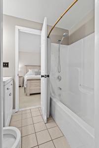 a bathroom with a shower and a toilet and a bed at 3BR Lake Luzerne Retreat with Game Room & Hot Tub in Lake Luzerne +28 photos