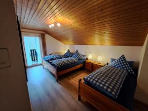 a bedroom with two beds and a wooden ceiling at Ferienwohnung Martin in Thalfang