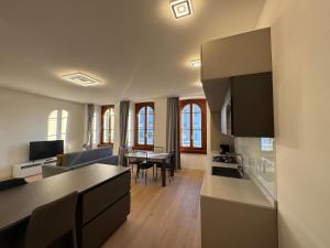a kitchen and a living room with a table at Pep's Rooms by the sea in Trieste