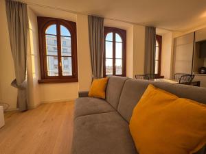 a living room with a couch and two windows at Pep's Rooms by the sea in Trieste
