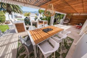 a patio with a wooden table and chairs at Cottage Sauvignon in Plumstead