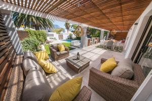a patio with a couch and chairs and a table at Cottage Sauvignon in Plumstead