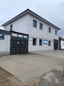 a large white building with two garage doors at Karakalpak Travel in Nukus