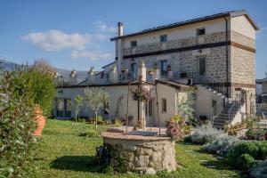a building with a fountain in front of a yard at Casale nel Verde con Piscina e Vista in Spigno Saturnia
