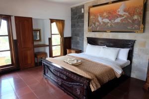 Schlafzimmer mit einem Bett mit Wandgemälde in der Unterkunft Puri Nusa Beach Hotel in Nusa Lembongan