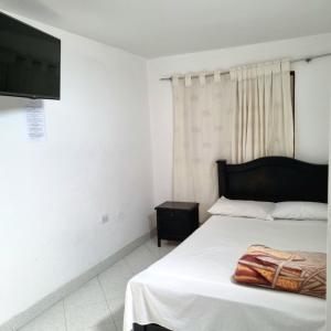 a bedroom with a bed and a flat screen tv at Hotel Iloa in Pitalito +10 photos