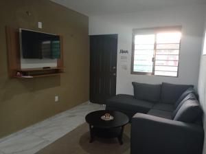 a living room with a couch and a table at Oasis suites Departamento5 planta alta in Campeche