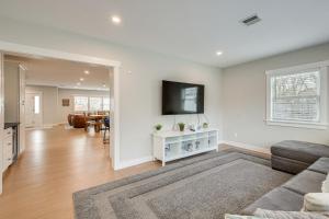 a living room with a couch and a tv on a wall at Modern Cape Cod Home with Patio 2 Mi to Beaches! in Hyannis