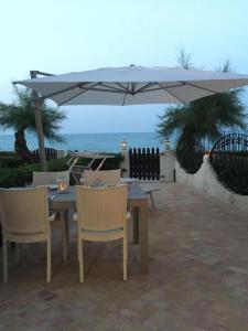 a table and chairs under an umbrella on a patio at Casa elegante in riva al mare in Vasto +22 photos