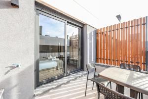 Elegant Studio with Private Terrace by RentitUP في سان سيباستيان دي لوس رييس: شرفة مع طاولة وكراسي وغرفة نوم