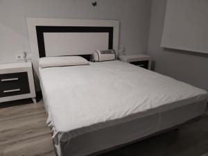 a bedroom with a large white bed with a machine on it at Castralvo Suites in Teruel