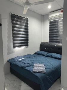 a bedroom with a bed with a blue comforter at Rumah Singgah Beaufort Homestay in Beaufort +13 photos