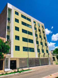 a yellow building with balconies on the side of it at Hotel Letiva Arco in Sobral