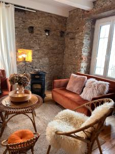 a living room with a couch and a brick wall at Maison de vacances - côte de Jade - coup de coeur in La Plaine-sur-Mer