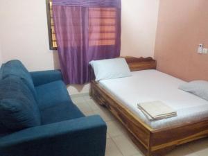 a small room with a bed and a chair at Hotel TK d'Or in Kpodji