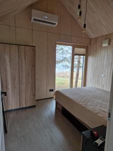 a bedroom with a bed and a large window at Aido ir Vido sodyba in Utena