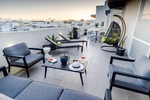 a balcony with a couch and chairs and a table at D Pool Top in Msida