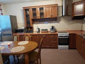 a kitchen with wooden cabinets and a table and a refrigerator at Dom Tatrzański Widok in Bustryk