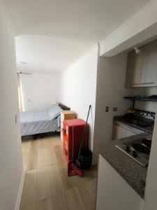 eine kleine Küche mit einem roten Koffer in einem Zimmer in der Unterkunft Depto Estudio con hermosa vista al mar in Valparaíso