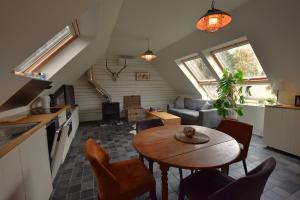 a kitchen and a living room with a table and chairs at Barque de Furnes in Ieper