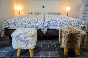 a bedroom with a bed with two ottomans at Barque de Furnes in Ieper