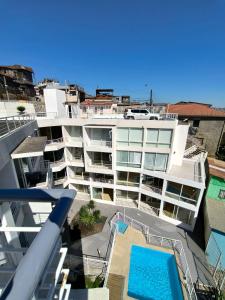 ein großes weißes Gebäude mit einem Pool davor in der Unterkunft Depto Estudio con hermosa vista al mar in Valparaíso