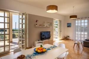 a living room with a table with a bowl of fruit on it at Breathtaking View - IsulaTravel in Marina di Modica