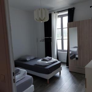 a small bedroom with a bed and a mirror at Ground floor apartment in farmhouse in Villiers-le-Bâcle