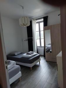 a small bedroom with two beds and a mirror at Ground floor apartment in farmhouse in Villiers-le-Bâcle
