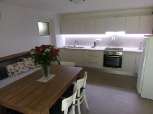 a kitchen with a wooden table with a vase of flowers on it at Chaloupka Bernartička in Boršov +14 photos