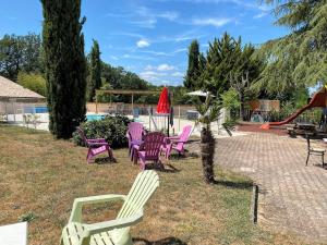 a group of chairs sitting in the grass near a pool at Camping le Faucon d'or in Montricoux +27 photos
