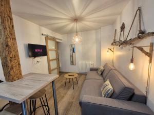 un soggiorno con un divano e un tavolo di studi'home a Rouen