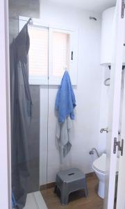 ein Bad mit einer Dusche und einem WC mit einem blauen Handtuch in der Unterkunft Apartment by the sea in Cubelles in Cubelles
