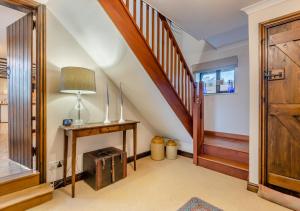 a hallway with a staircase with a table and a lamp at Ramblers Rest in Yarpole