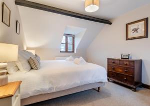 a bedroom with a white bed and a wooden dresser at Ramblers Rest in Yarpole